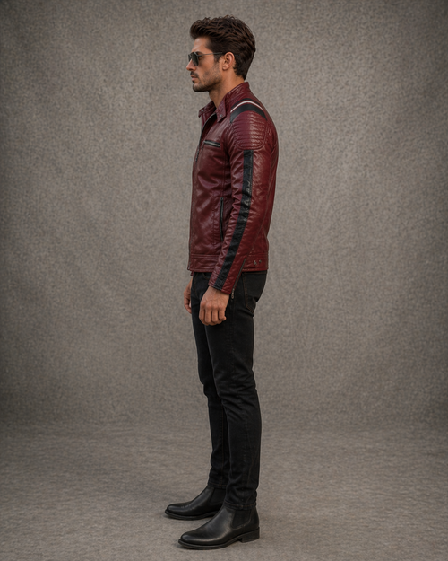 Man wearing a burgundy leather jacket with black accents on a gray background