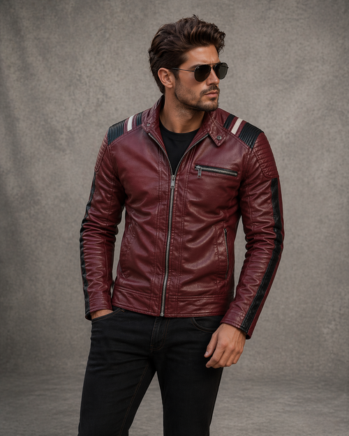 Man wearing a burgundy leather jacket with black pants against a gray background